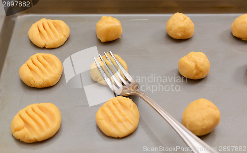 Image of Flattening balls of cookie dough 