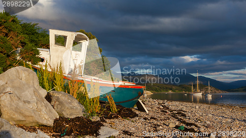 Image of Small shipwreck at a loch with stone beach