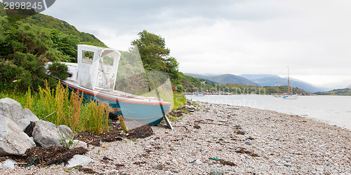 Image of Small shipwreck at a loch with stone beach