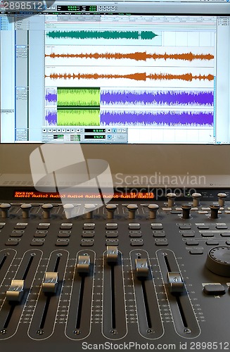 Image of Professional audio mixer with sliders and sound waves
