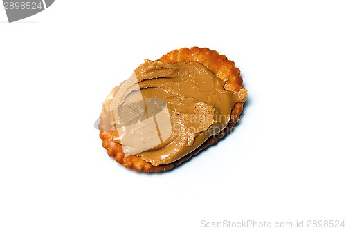 Image of oval cracker with peanut butter over white