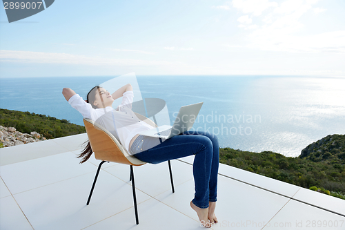 Image of relaxed young woman at home working on laptop