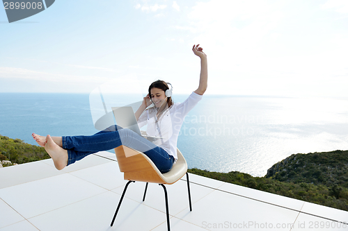 Image of relaxed young woman at home working on laptop