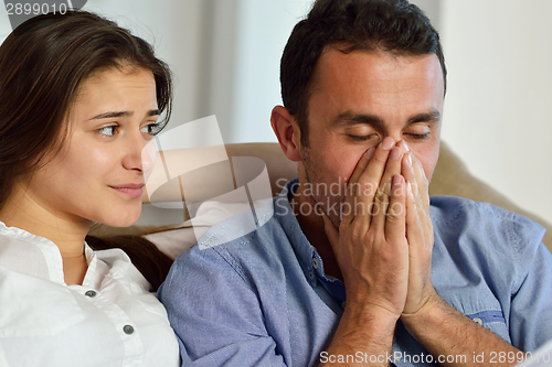 Image of relaxed young couple working on laptop computer at home