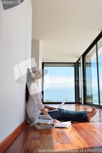 Image of relaxed young woman at home working on laptop