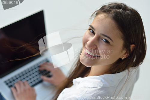 Image of relaxed young woman at home working on laptop computer