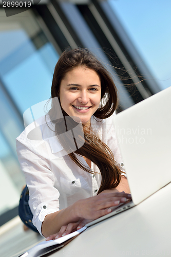 Image of relaxed young woman at home working on laptop computer