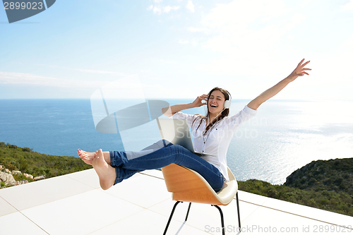 Image of relaxed young woman at home working on laptop