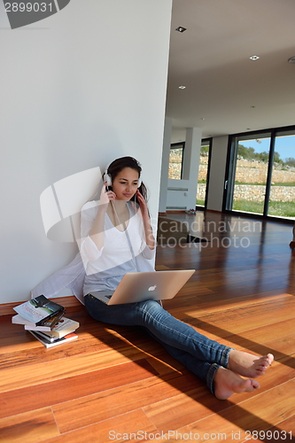 Image of relaxed young woman at home working on laptop