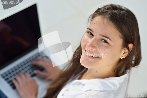 Image of relaxed young woman at home working on laptop computer