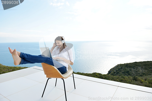 Image of relaxed young woman at home working on laptop
