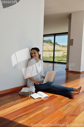 Image of relaxed young woman at home working on laptop
