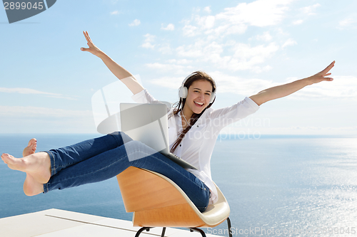Image of relaxed young woman at home working on laptop