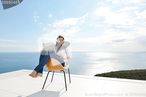 Image of relaxed young woman at home working on laptop