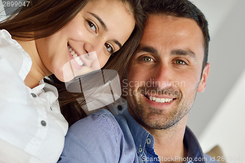 Image of relaxed young couple working on laptop computer at home