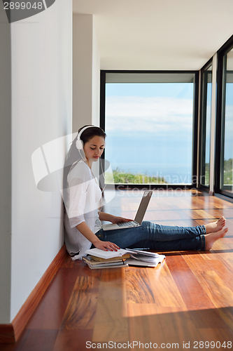 Image of relaxed young woman at home working on laptop
