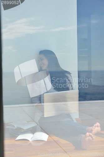 Image of relaxed young woman at home working on laptop computer