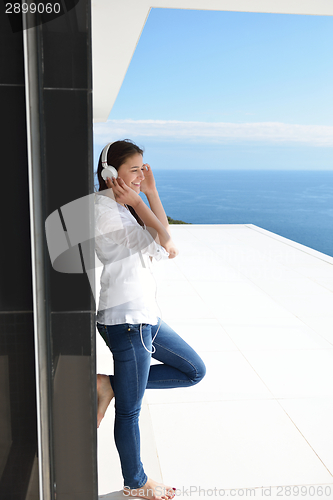 Image of girl listening to the music on white headphones