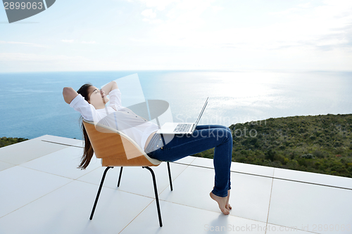 Image of relaxed young woman at home working on laptop