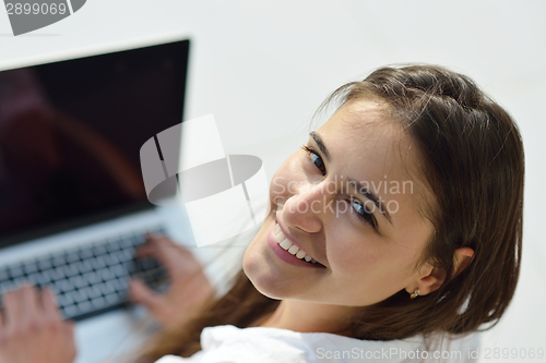 Image of relaxed young woman at home working on laptop computer