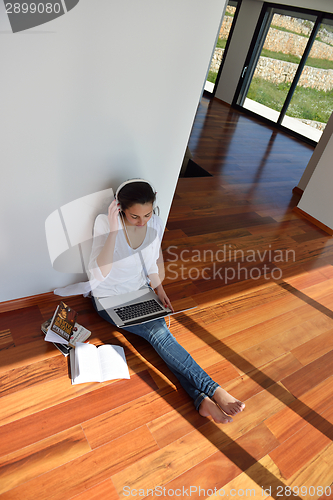 Image of relaxed young woman at home working on laptop