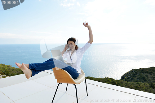 Image of relaxed young woman at home working on laptop