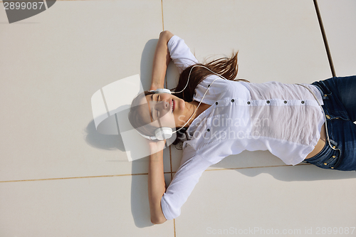 Image of girl listening to the music on white headphones