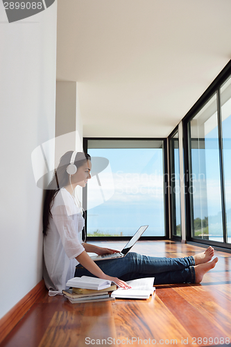 Image of relaxed young woman at home working on laptop