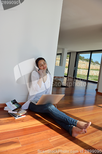 Image of relaxed young woman at home working on laptop