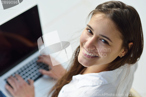 Image of relaxed young woman at home working on laptop computer