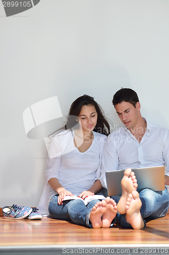 Image of relaxed young couple working on laptop computer at home