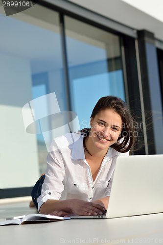 Image of relaxed young woman at home working on laptop computer