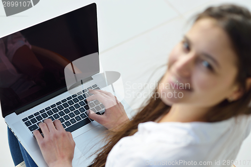 Image of relaxed young woman at home working on laptop computer