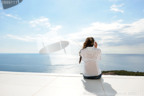 Image of girl listening to the music on white headphones