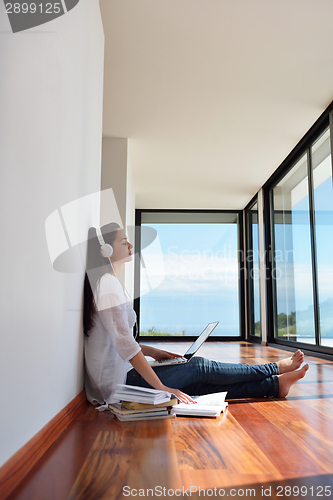 Image of relaxed young woman at home working on laptop