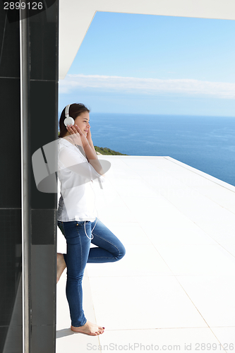 Image of girl listening to the music on white headphones