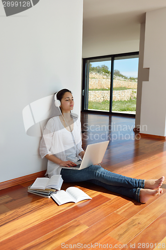 Image of relaxed young woman at home working on laptop