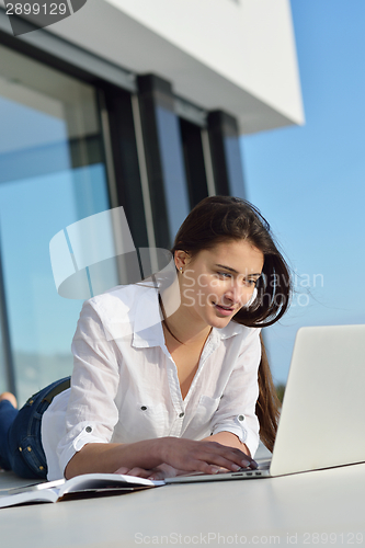Image of relaxed young woman at home working on laptop computer