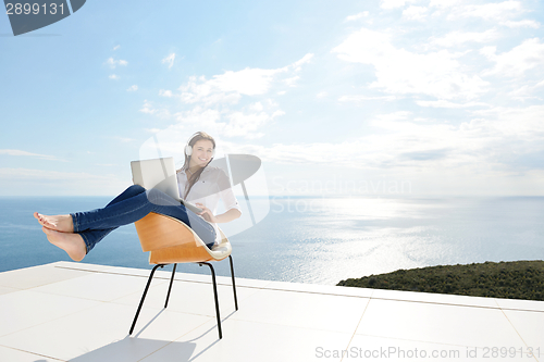 Image of relaxed young woman at home working on laptop