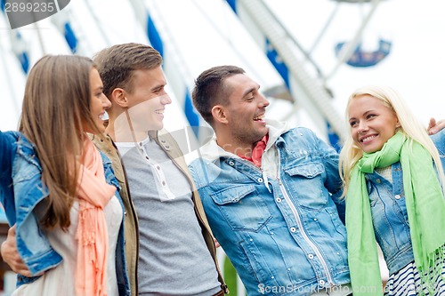 Image of group of smiling friends in amusement park