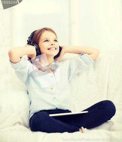 Image of girl with tablet pc and headphones at home