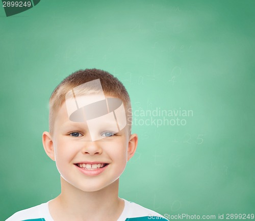 Image of smiling little boy over green board background