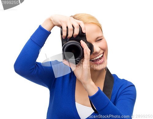 Image of smiling woman taking picture with digital camera