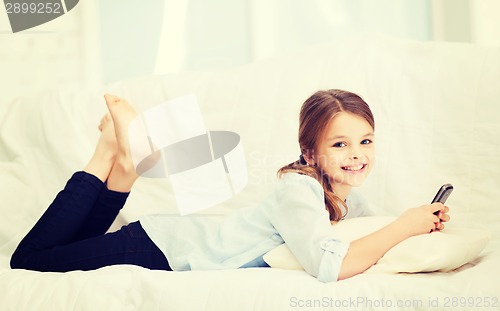 Image of smiling girl with smartphone at home