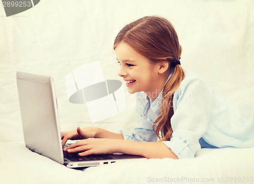 Image of smiling girl with laptop computer at home