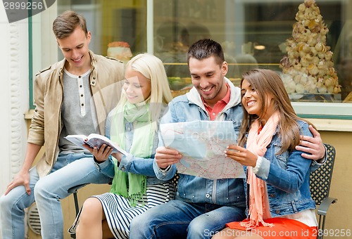 Image of group of friends with guide and map exploring town