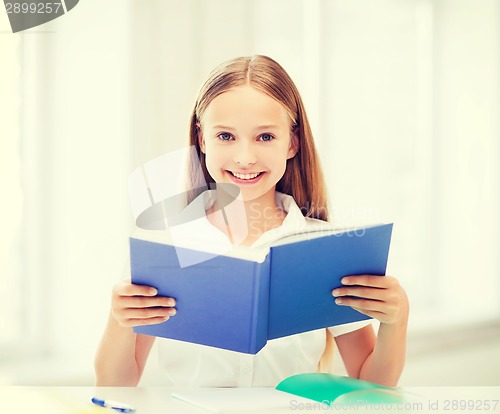 Image of girl studying and reading book at school
