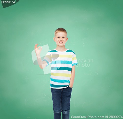 Image of little boy in casual clothes making OK gesture