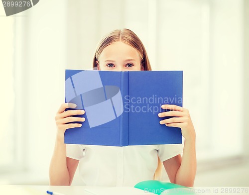 Image of girl studying and reading book at school