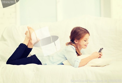 Image of smiling girl with smartphone at home